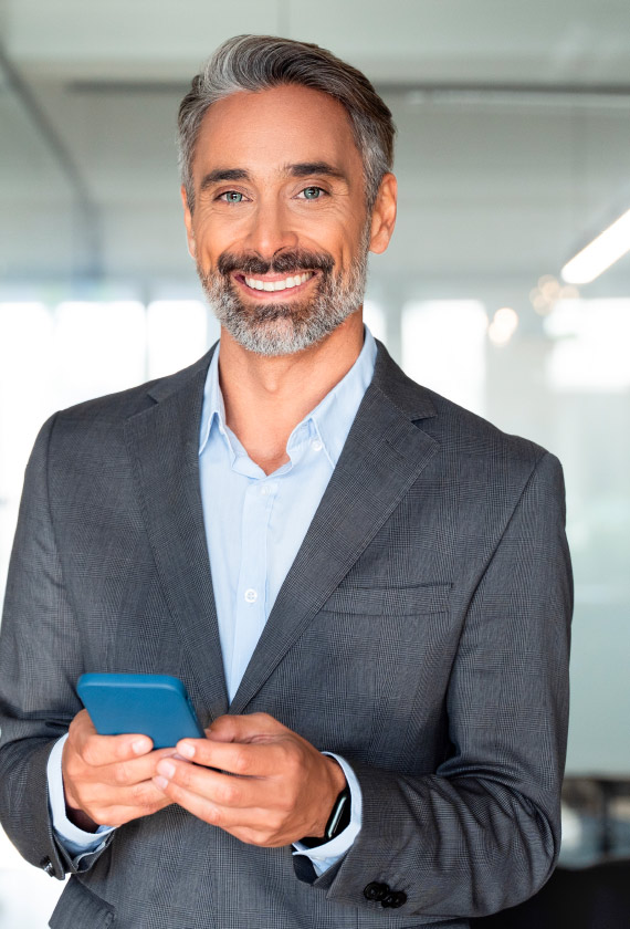 Homme souriant avec un téléphone à la main