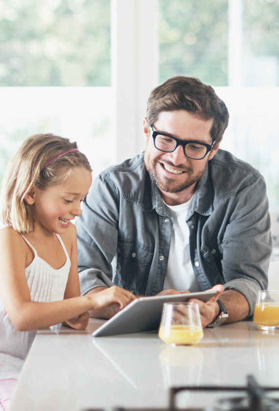 Père et fille jouant à la tablette